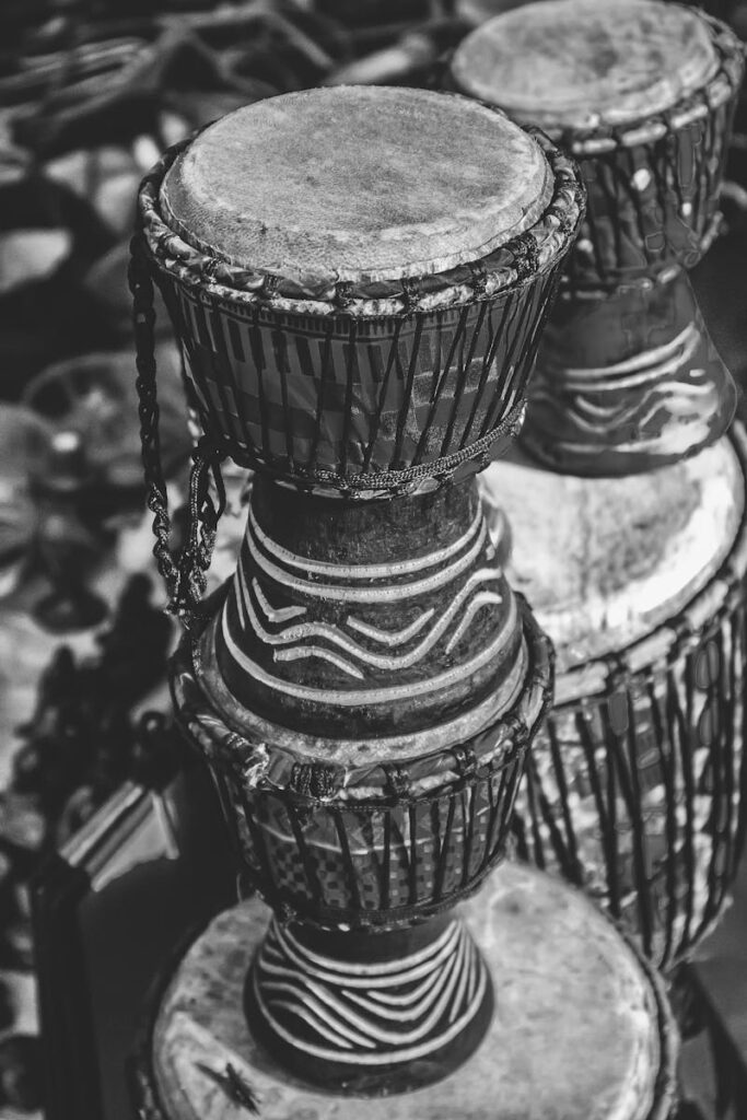 Close-up of traditional African djembe drums in black and white, highlighting patterns.